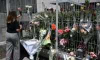 Une élève dépose une fleur sur les grilles du collège Françoise-Dolto à Nogent, au lendemain du meurtre d'une surveillante, le 11 juin 2025 en Haute-Marne ( AFP / FRANCOIS NASCIMBENI )