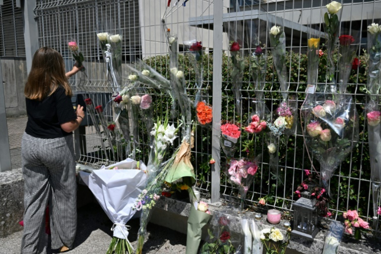 Une élève dépose une fleur sur les grilles du collège Françoise-Dolto à Nogent, au lendemain du meurtre d'une surveillante, le 11 juin 2025 en Haute-Marne ( AFP / FRANCOIS NASCIMBENI )
