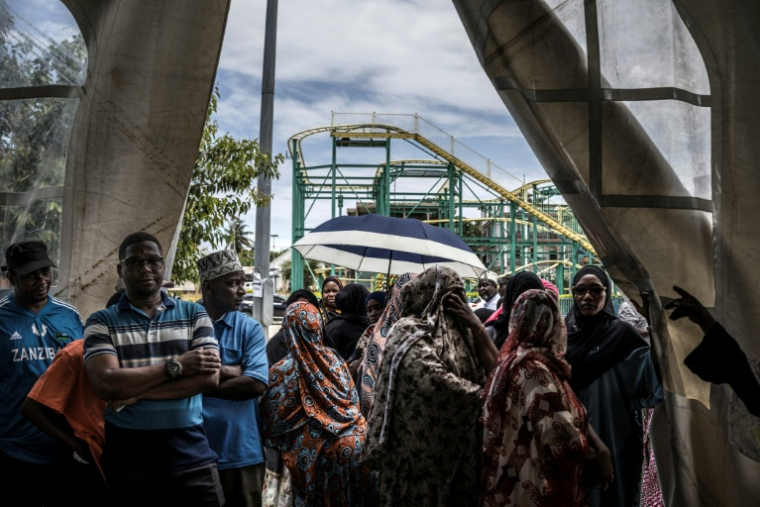 Des électeurs font la queue pour voter dans un bureau de vote situé près d'un parc d'attractions à Stone Town, le 29 octobre 2025, en Tanzanie ( AFP / MARCO LONGARI )