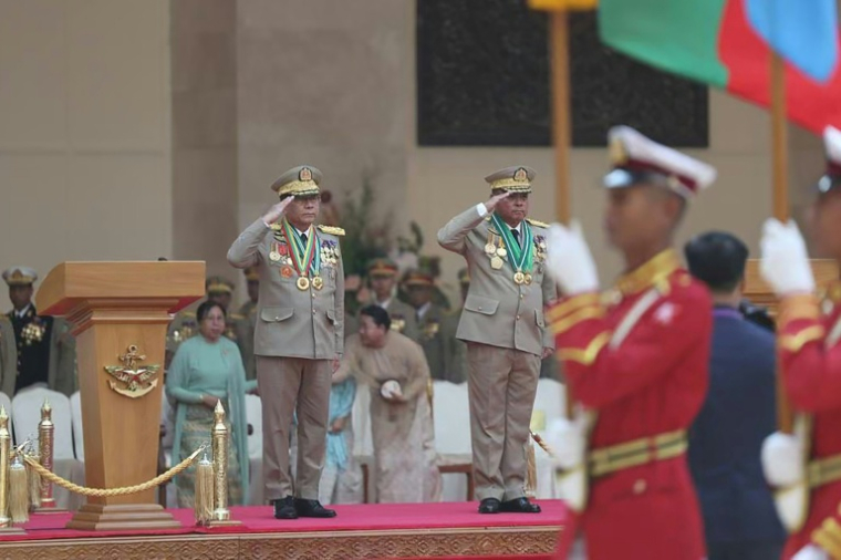 Cette photo fournie par l'armée birmane montre Min Aung Hlaing (G) et son successeur à la tête de l'armée Ye Win Oo (D sur l'estrade) à Naypyidaw, le 30 mars 2026 ( MYANMAR MILITARY INFORMATION TEAM / Handout )
