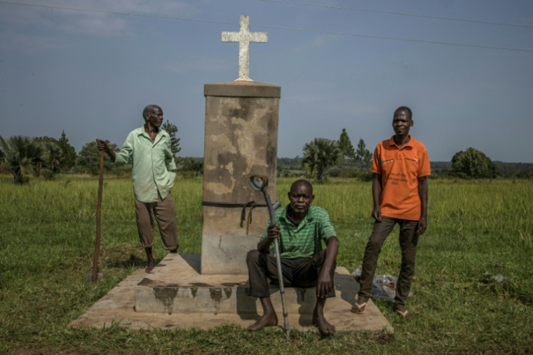 Des habitants réunis à côté d'un monument commémoratif du massacre de Lukodi dans le district de Gulu en Ouganda, le 4 septembre 2025 ( AFP / Stuart Tibaweswa )