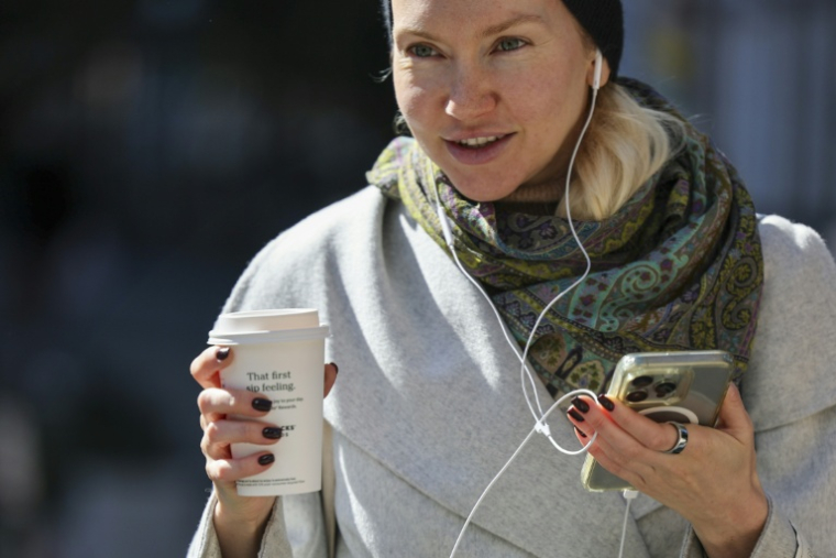 Une femme se déplace dans la rue avec son gobelet de café à New York, le 16 octobre 2025. ( AFP / ANGELA WEISS )