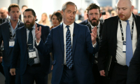 Le chef du parti Reform UK, Nigel Farage (c) arrive à la conférence du parti à Birmingham, dans le centre de l'Angleterre, le 5 septembre 2025 ( AFP / Oli SCARFF )