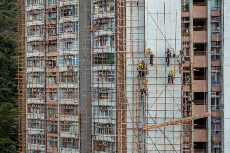 Des ouvriers installent des échafaudages en bambou sur un immeuble d'appartements en prévision de travaux de rénovation dans un complexe résidentiel du quartier de Chai Wan, le 12 septembre 2025 à Hong Kong ( AFP / Dale DE LA REY )