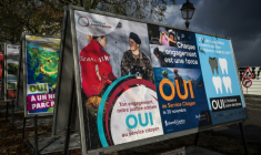 Des affiches électorales en faveur d'une initiative instaurant le devoir civique obligatoire pour tous dans une rue à Genève, le 25 novembre 2025 en Suisse ( AFP / Fabrice COFFRINI )