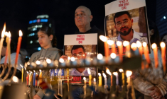 Des Israéliens portent des portraits de Ran Gvili lors de la fête juive d'Hanouka, à Tel Aviv le 21 décembre 2025 ( AFP / ILIA YEFIMOVICH )
