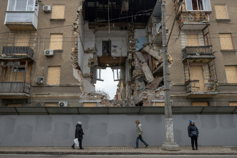Le 17 février 2026, à Odessa, en Ukraine, des civils passent devant un immeuble résidentiel fortement endommagé par une frappe aérienne russe ( AFP / Oleksandr GIMANOV )