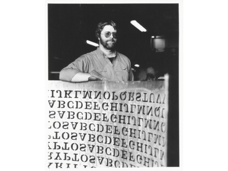 Cette photo de 1990, fournie par Jim Sanborn, montre le sculpteur Jim Sanborn avec un bout de sa sculpture en cuivre "Kryptos", installée au siège de la CIA, en Virginie, aux Etats-Unis  ( Courtesy of Jim Sanborn / HANDOUT )