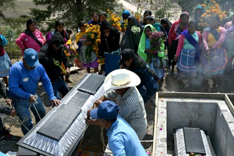 Des proches portent un cercueil lors des funérailles de membres d'un groupe d'autodéfense indigène après une attaque présumée de membres du cartel de la drogue Los Ardillos à Alcozacan, dans l'Etat de Guerrero au Mexique, le 20 mai 2026 ( AFP / YURI CORTEZ )