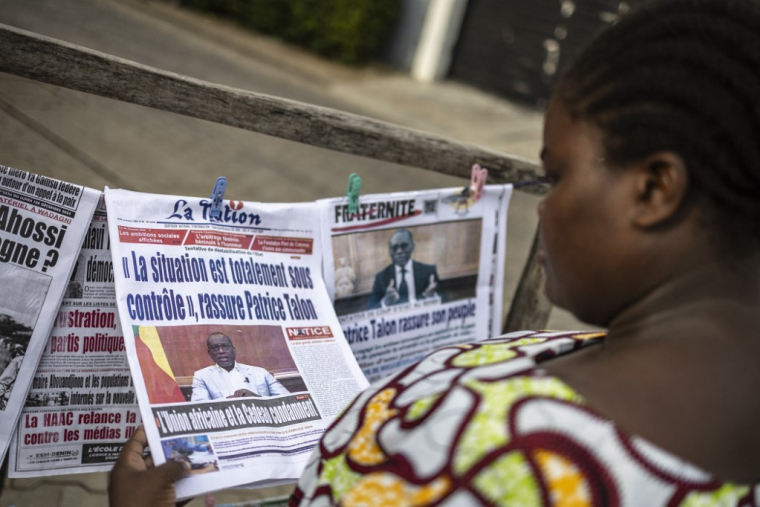 Une passante lit un journal à Cotonou, au Bénin, le 8 décembre 2025. ( AFP / OLYMPIA DE MAISMONT )