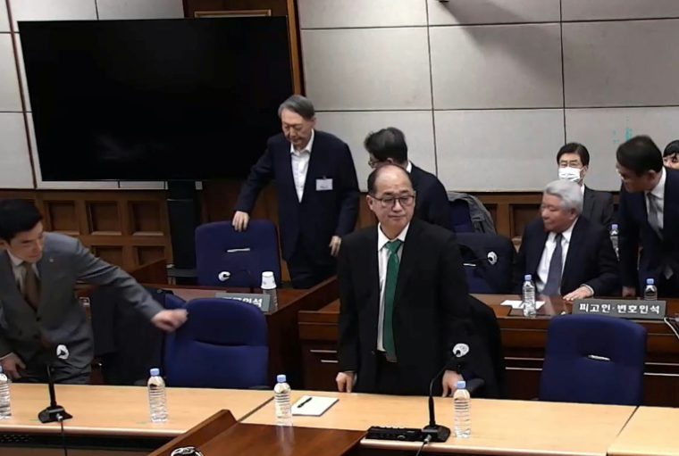 Cette capture d'écran tirée d'une vidéo distribuée par le tribunal central de Séoul et diffusée par l'agence Yonhap montre l'ancien président sud-coréen Yoon Suk Yeol (2e rangée, à gauche) assistant à un procès pour insurrection au tribunal central de Séoul, le 19 février 2026 ( YONHAP / Handout )