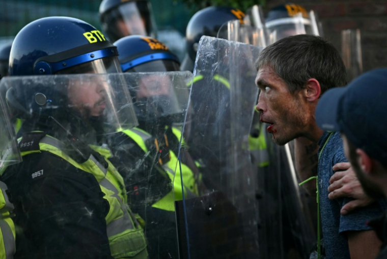 Un manifestant réagit après avoir donné un coup de pied à un policier et avoir été poussé au sol, près du commissariat de Portswood, lors d’une marche de protestation contre la police à Southampton, dans le sud de l’Angleterre, le 2 juin 2026 ( AFP / JUSTIN TALLIS )
