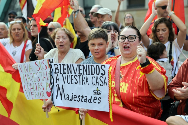 Des habitants tiennent des pancartes souhaitant la bienvenue au couple royal espagnol à Ceutra le 13 octobre 2026 ( AFP / Thomas COEX )