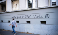 Un homme passe devant un graffiti dans une rue proche de l'entrée du lycée privé catholique et du Collège Saint-Stanislas à Nantes, le 29 août 2025 ( AFP / Loic VENANCE )