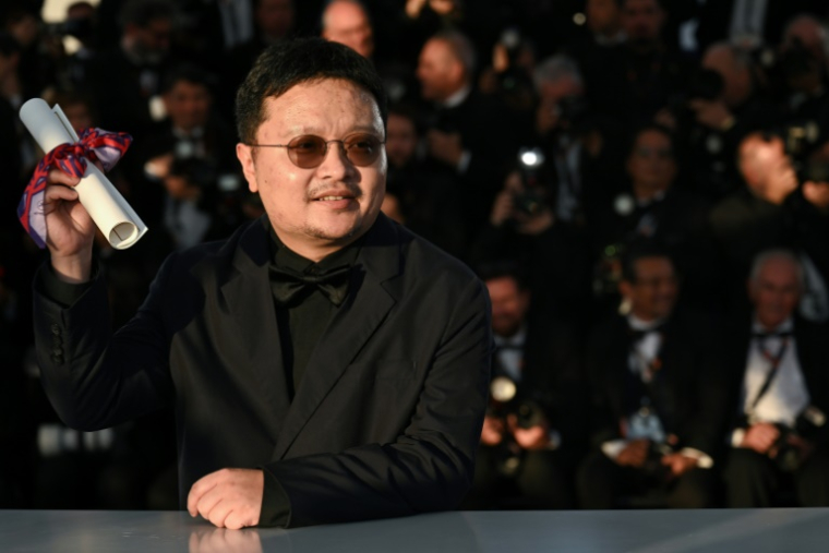 Le réalisateur chinois Bi Gan avec son prix spécial pour "Résurrection", le 24 mai 2025 au festival de Cannes ( AFP / Bertrand GUAY )