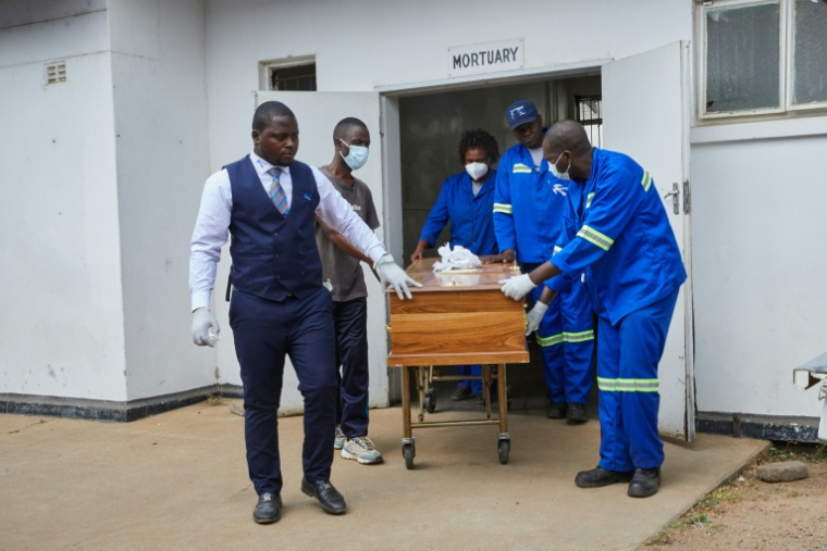 Le cercueil d'une victime du naufrage d'un ferry est sorti de la morgue de l'hôpital de Kariba, au Zimbabwe, le 14 août 2026 ( AFP / Jekesai NJIKIZANA )