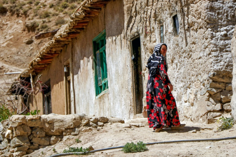 Une femme afghane issue de la communauté hazara devant sa maison dans un village du district de Shibar, dans le centre de l'Afghanistan, le 18 juin 2025  ( AFP / Mohammad Faisal NAWEED )