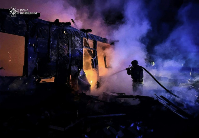 Photo diffusée par le Service d'urgence ukrainien, le 1er mai 2025, montrant un pompier ukrainien éteignant un incendie sur le site d'une attaque de drone russe à Kiev ( Service d'urgence ukrainien / Handout )