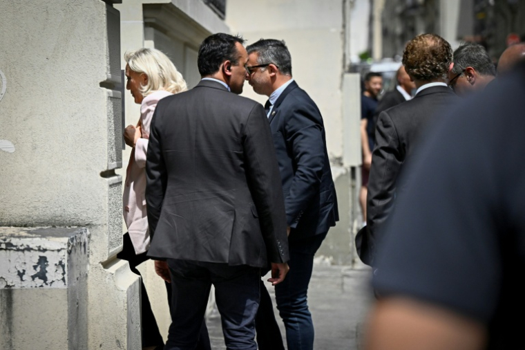 Marine Le Pen (g), présidente du groupe parlementaire du Rassemblement national (RN), arrive au nouveau siège du parti, le 7 juillet 2026 à Paris, après avoir été condamnée par la cour d'appel de Paris lors du procès en appel pour détournement de fonds publics européens dans l'affaire des emplois présumés fictifs au Parlement européen ( AFP / JULIEN DE ROSA )