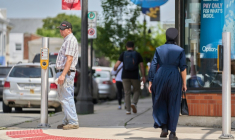 Une femme en tenue traditionnelle mennonite dans une rue du centre-ville d'Aylmer, le 9 juillet 2025 au Canada ( AFP / Geoff Robins )