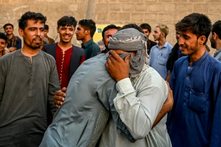 Des réfugiés afghans s'enlacent avant de partir pour l'Afghanistan, à Karachi, le 8 avril 2025 ( AFP / Asif HASSAN )