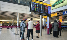 Des passagers devant le comptoir d'enregistrement fermé de la compagnie aérienne Qatar Airways, le 1er mars 2026 à l'aéroport Heathrow de Londres  ( AFP / JUSTIN TALLIS )