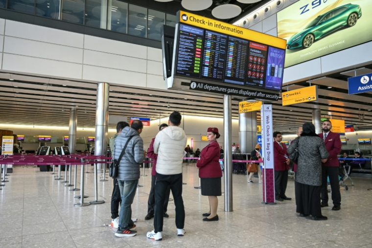 Des passagers devant le comptoir d'enregistrement fermé de la compagnie aérienne Qatar Airways, le 1er mars 2026 à l'aéroport Heathrow de Londres  ( AFP / JUSTIN TALLIS )