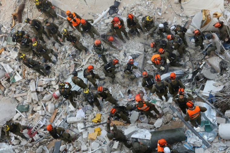 Des secouristes fouillent les décombres après une frappe de missile iranienne à Bat Yam, dans le centre d'Israël, le 15 juin 2025 ( AFP / GIL COHEN-MAGEN )