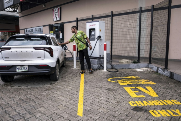 Un conducteur recharge sa voiture électrique dans une station de recharge publique près de Lagos le 3 juin 2026, au Nigeria ( AFP / Temiloluwa Johnson )