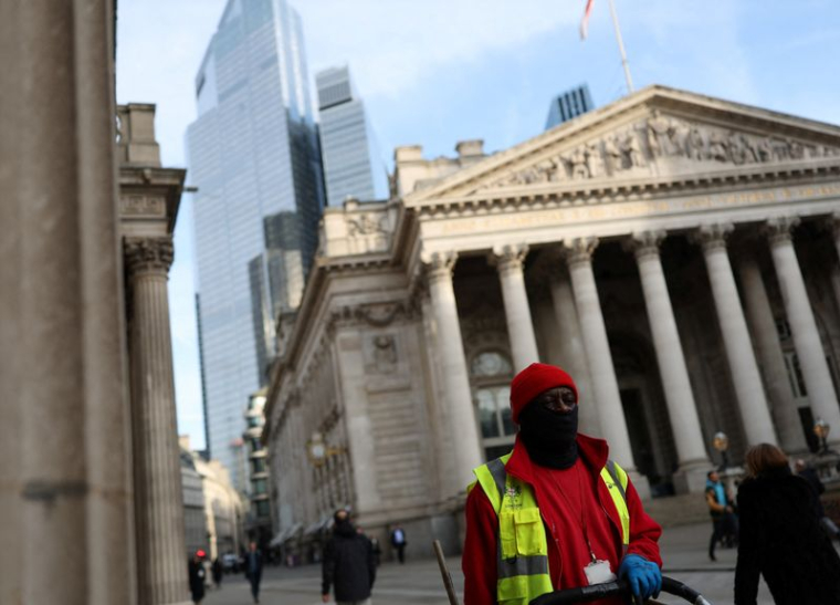 Un balayeur passe devant le bâtiment du Royal Exchange à Londres
