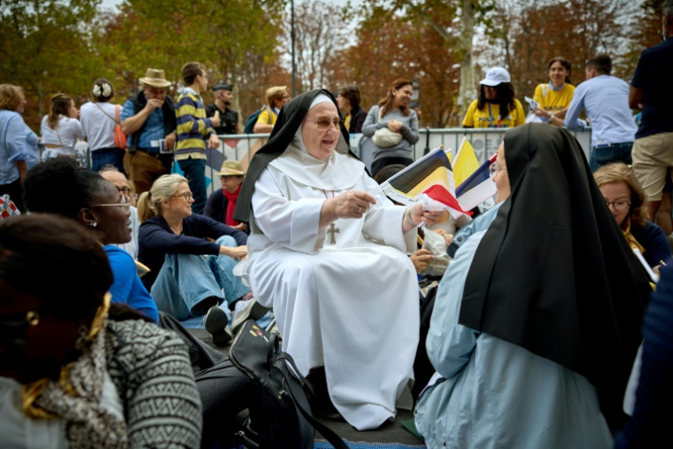 Des fidèles sur les Champs-Elysées avant la messe du pape Léon XIV le 26 septembre 2026 ( AFP / Kiran RIDLEY )
