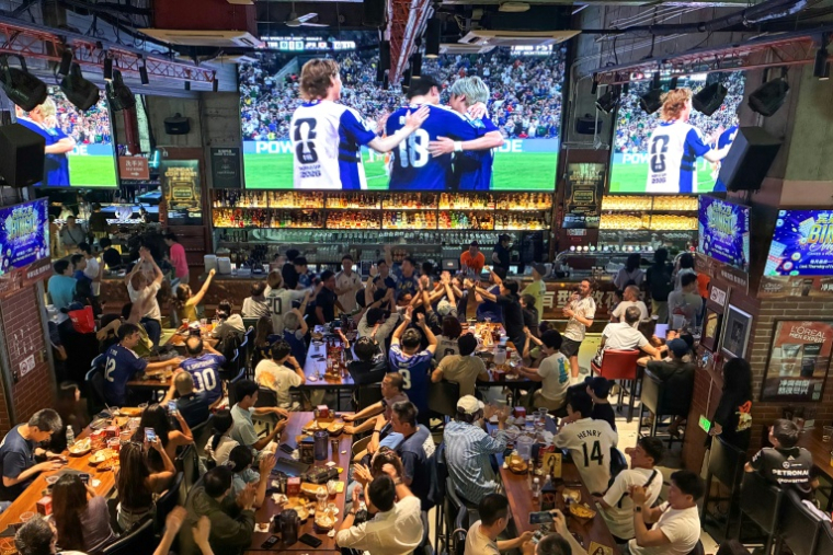 Le bar des sports "Cages" à Shanghai, diffusant la rencontre entre le Japon et la Tunisie, le 21 juin 2026 ( AFP / Rebecca BAILEY )