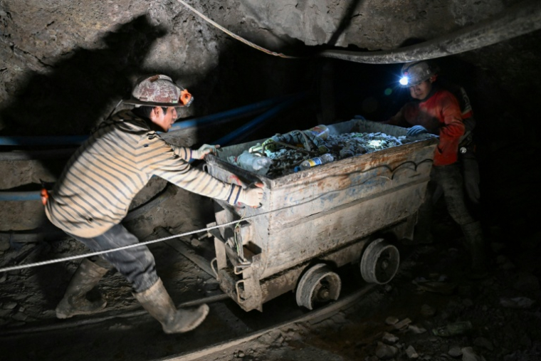 Des mineurs poussent un wagon chargé de minerais dans la mine du Cerro Rico, à Potosi, en Bolivie, le 19 février 2026 ( AFP / Aizar RALDES )