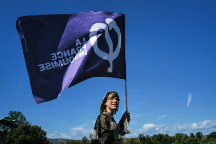 Une sympathisante de La France insoumise (LFI) tient un drapeau lors des universités d'été du parti (LFI), le 22 août 2026 à  Châteauneuf-sur-Isère, dans la Drôme  ( AFP / OLIVIER CHASSIGNOLE )