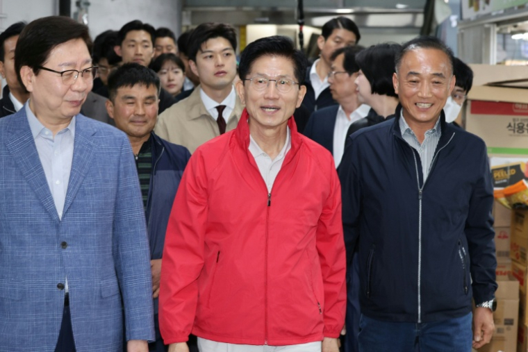 Kim Moon-soo (C), le candidat du Parti du pouvoir au peuple (PPP), en campagne au marché de Garak à Séoul, le 12 mai 2025 ( YONHAP / - )