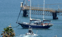 Un bateau de patrouille de la police israélienne se dirige le bateau Madleen amarré au port d'Ashdod après avoir été intercepté la veille par les forces israéliennes, le 10 juin 2025 ( AFP / Jack GUEZ )