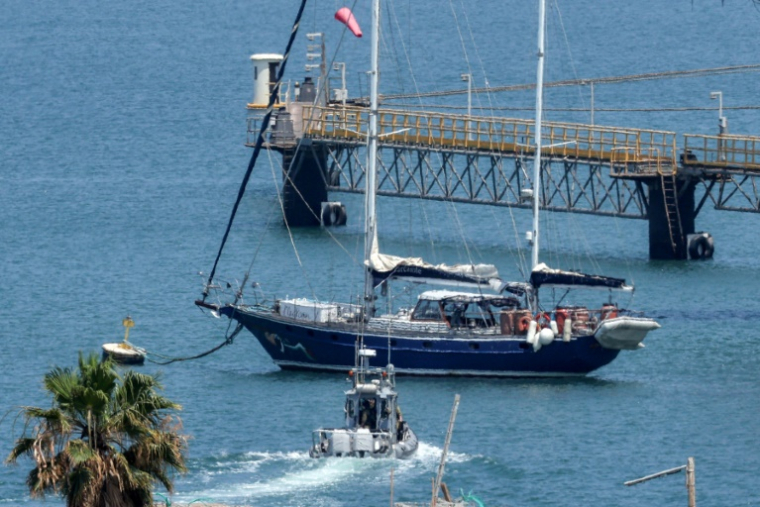 Un bateau de patrouille de la police israélienne se dirige le bateau Madleen amarré au port d'Ashdod après avoir été intercepté la veille par les forces israéliennes, le 10 juin 2025 ( AFP / Jack GUEZ )