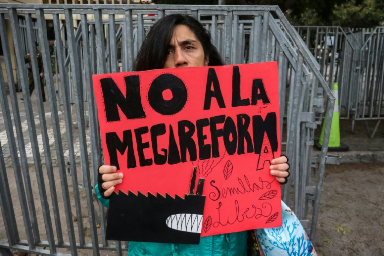 Une personne manifeste devant le Congrès national à Valparaiso au Chili pendant le débat au Sénat sur un projet de réforme économique, le 15 juillet 2026 ( AFP / Cristobal BASAURE )