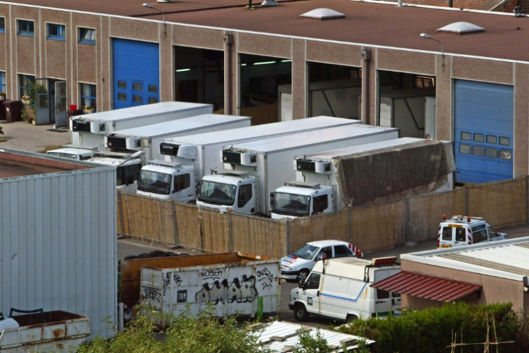 Neuf camions réfrigérés où reposent une centaine de corps provenant de morgues d'Ile-de-France saturées, le 24 août 2003 à Ivry-sur-Seine, dans le Val-de-Marne, après un épisode de canicule qui a causé quelque 15.000 morts ( AFP / MEHDI FEDOUACH )