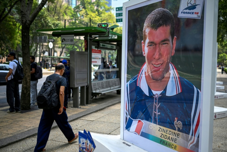 Un homme marche près d'une photo de l'ancien footballeur français Zinedine Zidane, lors d'une exposition consacrée à l'album Panini de la Coupe du monde, sur l'avenue Reforma à Mexico, le 11 mai 2026 ( AFP / Alfredo ESTRELLA )