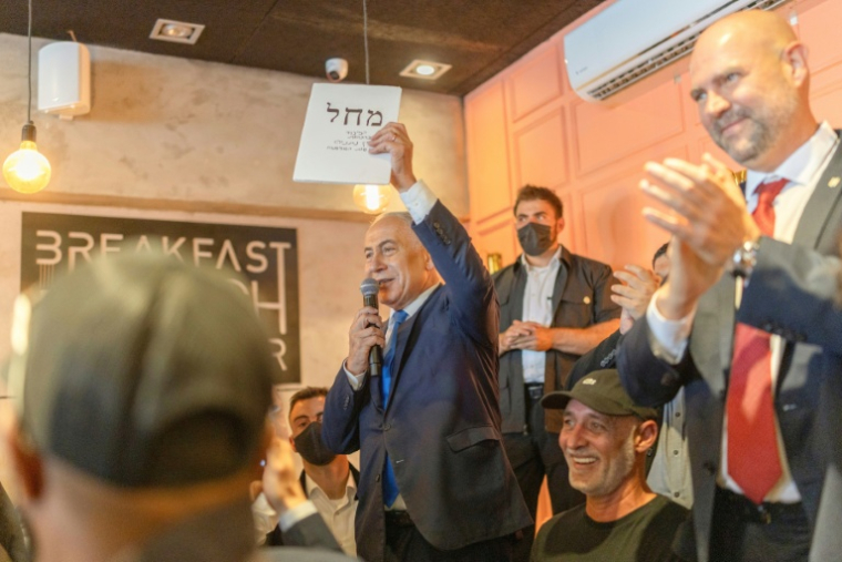 Le Premier ministre israélien Benjamin Netanyahu (d) s'adresse à ses sympathisants dans un café à Dimona, le 21 octobre 2026 en Israël ( AFP / Ilia YEFIMOVICH )