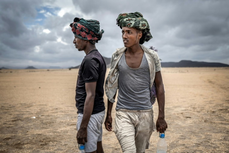 Des migrants éthiopiens marchent le 12 avril 2026 dans le désert, près d'Obock, à Djibouti, sur la Route de l'Est reliant la Corne de l'Afrique aux pays du Golfe, via le Yémen ( AFP / Luis TATO )