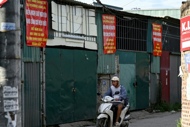 Des affiches de protestation contre un vste porjet de réaménagement dans une rue d'un quartier de Hanoï, le 19 juin 2026 au Vietnam ( AFP / STR )