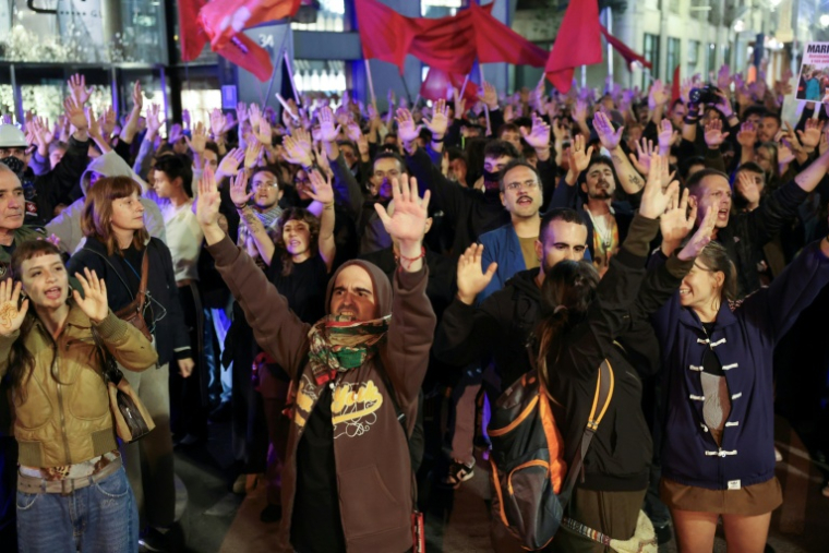 Des manifestants lèvent les bras lors d'un rassemblement de protestation et de recueillement, après avoir appris le décès de la retraitée Maricarmen Abascal, expulsée de son logement, dans un hôpital à Madrid, le 7 octobre 2026 ( AFP / Thomas COEX )