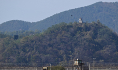 Un poste de garde nord-coréen (h,d) et un haut-parleur géant, du côté nord de la zone démilitarisée (DMZ) séparant les deux Corées, visibles depuis Paju, le 20 octobre 2026 en Corée du Sud ( AFP / Jung Yeon-je )