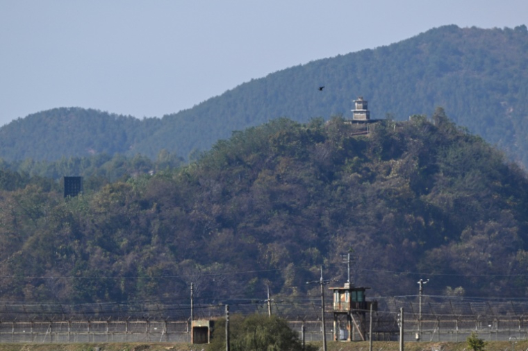 Un poste de garde nord-coréen (h,d) et un haut-parleur géant, du côté nord de la zone démilitarisée (DMZ) séparant les deux Corées, visibles depuis Paju, le 20 octobre 2026 en Corée du Sud ( AFP / Jung Yeon-je )