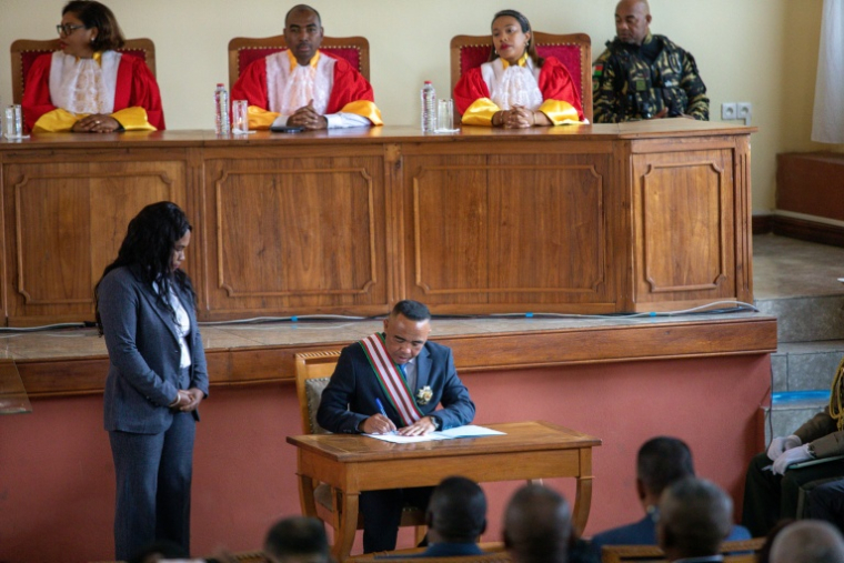 Le colonel Michaël Randrianirina, au centre, signe les documents de sa prestation de serment en tant que président, pendant sa cérémonie d'investiture, le 17 octobre 2025 à Antananarivo, à Madagascar ( AFP / Mamyrael )