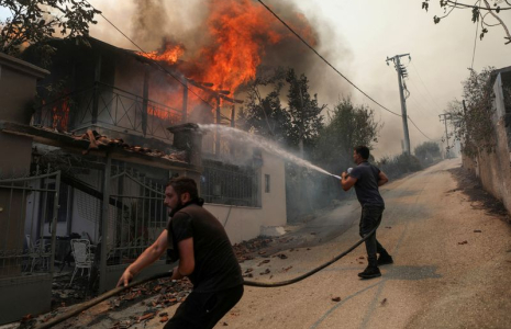 Des volontaires tentent d'éteindre un incendie dans une maison près d'Athènes, en Grèce