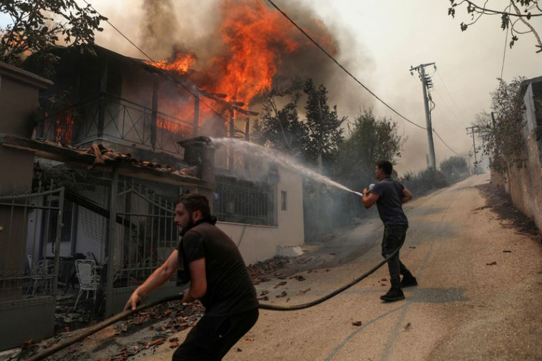 Des volontaires tentent d'éteindre un incendie dans une maison près d'Athènes, en Grèce