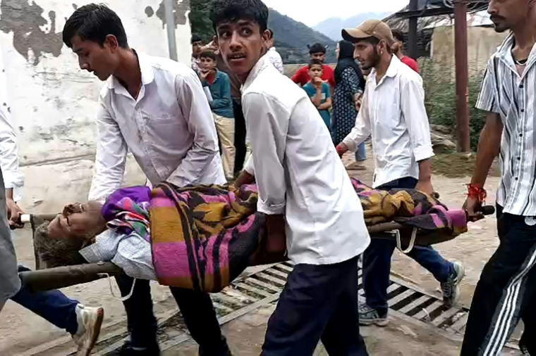 Des hommes transportent un blessé dans une civière à l'hôpital de Kishtwar en Inde le 14 août 2025 après des inondations au Cachemire  ( AFPTV / Imran Shah )
